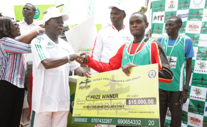 Edo Governor Adams Oshiomhole presents a cheque to Timothy Toroitich from Uganda, 2nd prize winner with time of 29 mins, 44 seconds at the Okpekpe Road Race 10km.