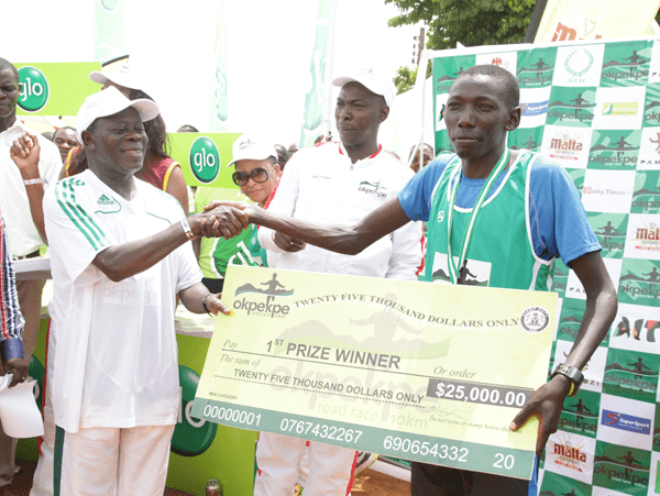 Edo Governor Adams Oshiomhole presents a cheque to Kenyan Moses Masai, Winner with time of 29 mins & 39 seconds at the Okpekpe Road Race 10km.
